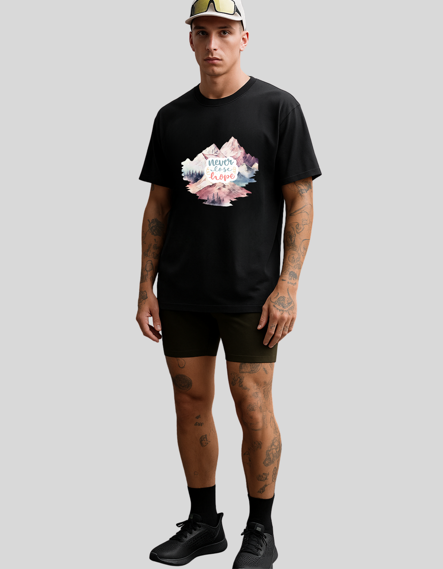 Man wearing a black t-shirt with a colorful graphic design on a plain background